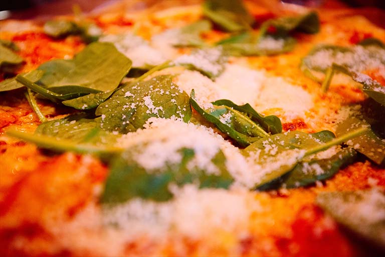 Spinach on pizza close-up