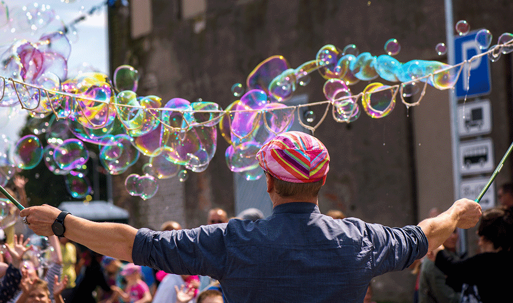 man blowing bubbles at outdoor performance